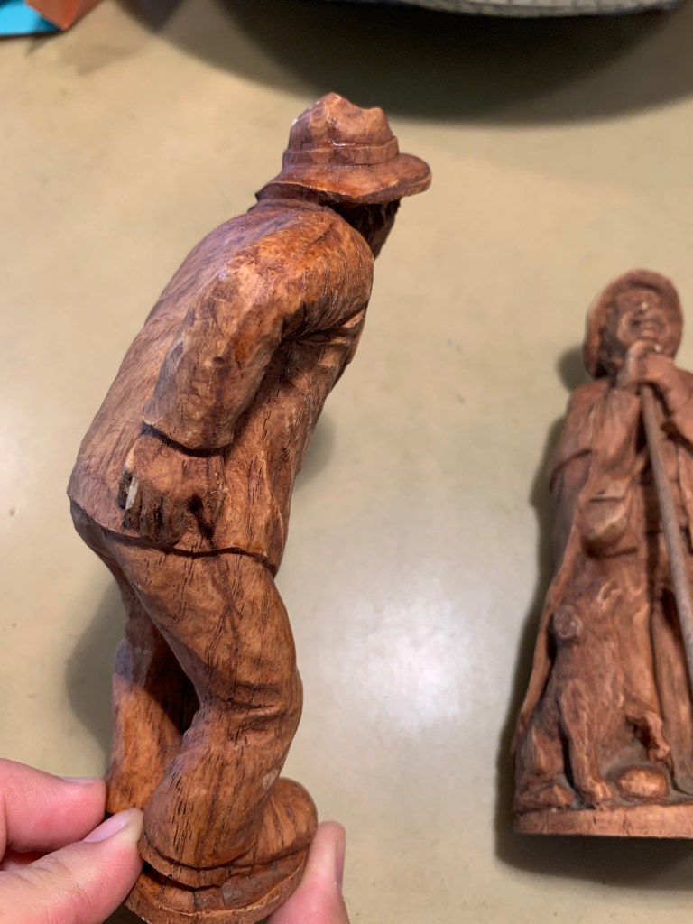 A very wood-looking figurine with a dark line down the side where the stain highlights the molding line.